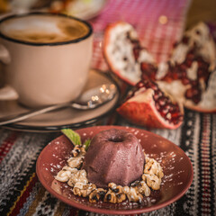 a cup of cocoa, pudding and pomegranate, chocolate puding in the glass with pomegranate.Supangle or pudding