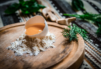 Fresh egg in heap of wholemeal flour on marble table. dough for pizza or pasta. place for text. top view. vertical image.