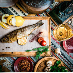 Turkish or Greek restaurant table and food dinner cuisine culture from top view. Traditional Greek ouzo or turkish raki with grilled or fried fish and appetizers on dinner table at restaurant.