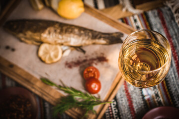 Mediterranean food, smoked Herring fish served with green onion,lemon,cherry tomatoes,spices,bread and Tahini sauce on dark background.Top view with close-up
