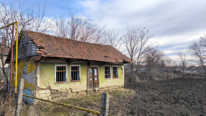 Fototapeta na wymiar An empty old house sitting empty in an abandoned field