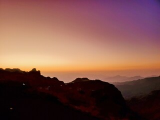 A unique view of the sunset in a colorful sky over high mountains