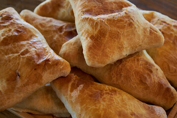 Triangular puff pastry samosas. Fresh baked goods: samsa with meat or potato close up, side view. Delicious Asian food, Traditional eastern cuisine Tajikistan, Uzbekistan, Kyrgyzstan, Kazakhstan. 