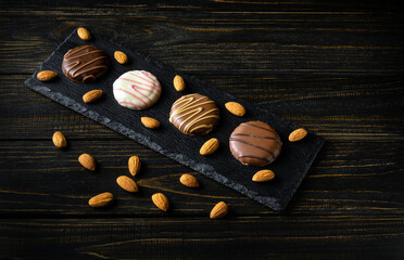 Cookies with nuts on a serving board in dark and white chocolate icing. Concept of delicious...