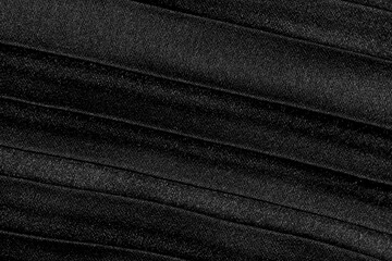 Close-up of a textured fabric with repetitive dark lines creating an abstract, elegant pattern suitable for backgrounds, design, and noir-themed projects.