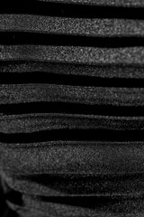 Elegant vertical folded black silk fabric texture background close-up overlay fashion dress