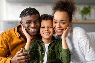 Cheerful black family with son sharing loving moment