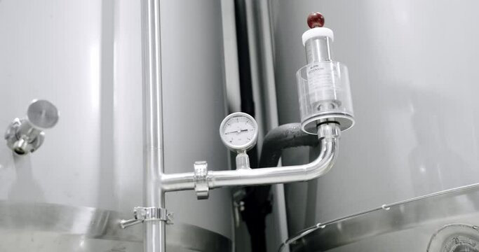 Detail view of detectors for measuring pressure in reservoirs on producing beer. Thermostat temperature going up. Grain of malt in a beer tank in a factory. Boiling grain malt. brewery. Making beer.