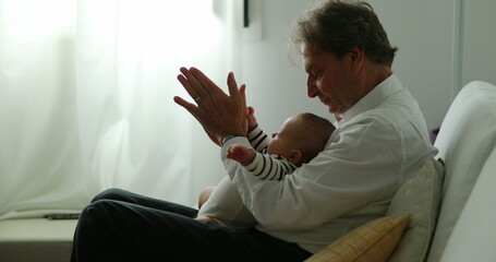 Authentic grandfather with grandson baby newborn at home candid - obrazy, fototapety, plakaty