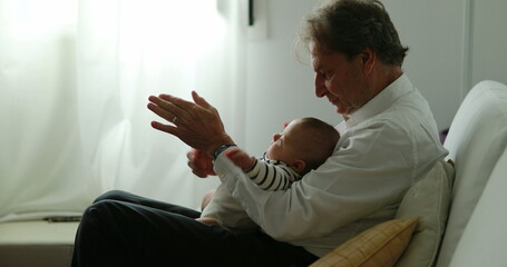 Authentic grandfather with grandson baby newborn at home candid