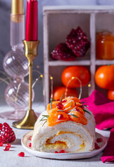 Meringue roll filled with mascarpone, cream and tangerine jam, decorated with tangerines and pomegranate seeds. - 729504477