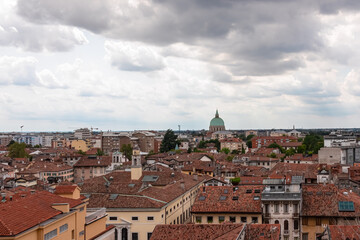 Naklejka premium Aerial panoramic view of historic city of Udine, Friuli Venezia Giulia, Italy, Europe. Viewing platform form castle of Udine. Dark clouds on overcast day. Classical Italian architecture red roofs