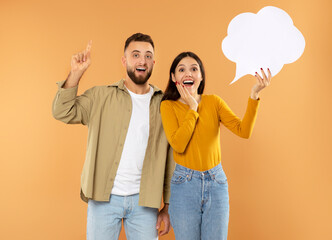 couple holding empty thought bubble pointing finger up, orange background