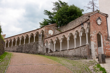Fototapeta premium Scenic pedestrian path along renaissance Venetian gothic style arcade leading to castle of Udine, Friuli Venezia Giulia, Italy, Europe. Italian architecture columns and arches. Travel destination