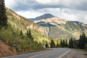Fototapeta premium Asphalt deserted road through the Rocky Mountains autumn landscape of Colorado, USA. 