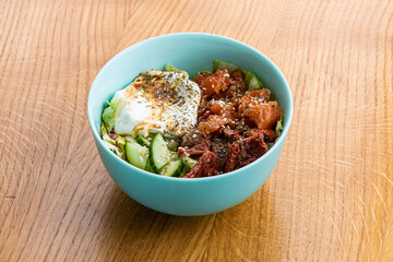 Bowl with salmon, sun-dried tomatoes and cucumber