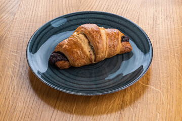 Classic croissant on a turquoise plate