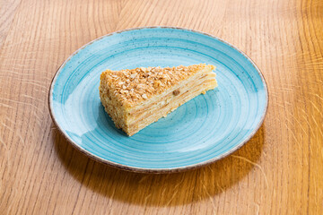 Piece of Napoleon cake on a blue plate