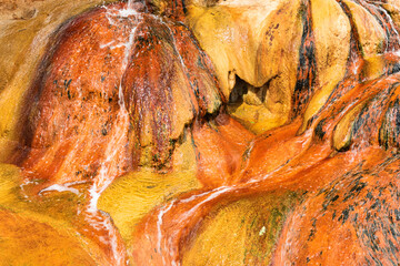 Macro, closeup of brightly colored mineral deposits from the Pinkerton Hot Spring outside of Durango Colorado, USA. 