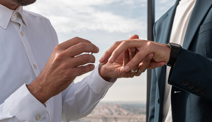 Gay couple putting on their weddings rings