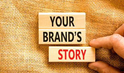 Branding and your brand story symbol. Concept words Your brands story on beautiful wooden blocks. Beautiful canvas background. Businessman hand. Business branding your brand story concept. Copy space.