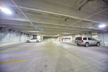 Sparse Indoor Parking Garage with Bright Lights and Two Cars