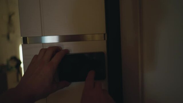 POV of a person using a digital peephole to check outside before opening the front door, shot handheld in low light