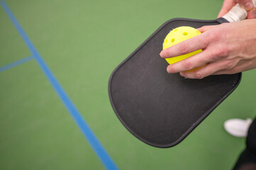 hand on the pickle ball racket