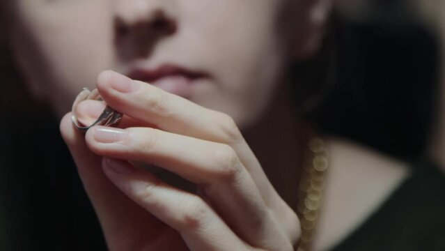 Woman goldsmith looking at crafted silver ring. Jewelry handicraft. Close up