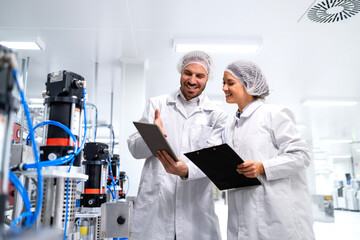 Factory technologists monitoring production process and analyzing results together.