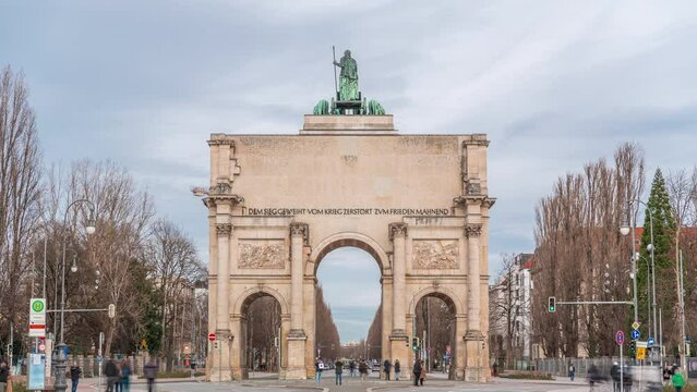 The Siegestor or Victory Gate in Munich is a memorial arch, crowned with a statue of Bavaria with a lion quadriga timelapse. Traffic on the street around the monument. Back view. Germany