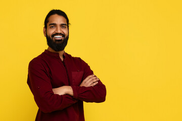 Confident young indian guy posing with arms crossed on chest