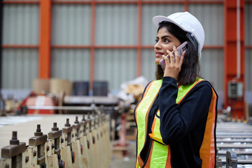 worker or engineer talking on smartphone and looking above in the factory