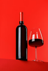 Red wine elegance: Wine glass and bottle against vibrant red background