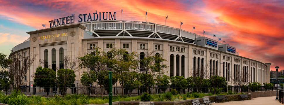 New York, USA; June 3, 2023: Spectacular panoramic view of the famous Yankee Stadium in the Bronx at sunrise or sunset with orange sky.