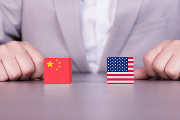 USA, China trade war, conflict of interest. Flags of America and China on wooden cubes on the...