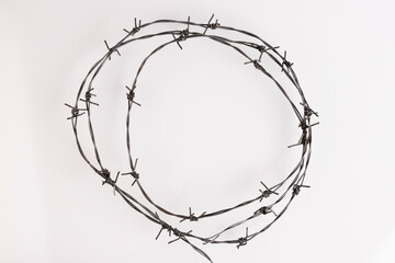 Barbed wire on a white background. Close-up, with sharp spikes arranged in a circle. copy space.