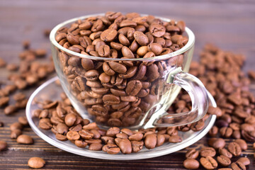 Coffee beans in a transparent glass cup. Close-up.
