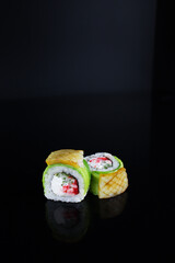 sushi rolls with avocado and squid on a black background