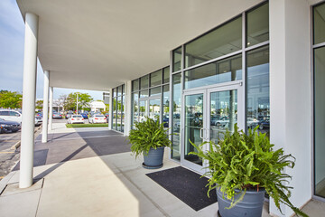 Modern Commercial Building Entrance with Greenery and Reflections