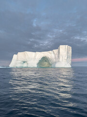 A huge high breakaway glacier drifts in the southern ocean off the coast of Antarctica at sunset,...