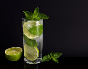 Mojito cocktail in the drinking glass on the black background. Copy space.