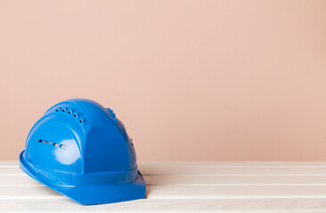 Fototapeta premium Blue construction helmet on wooden table