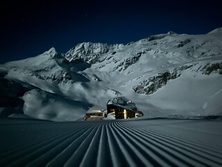 Hütte mit Schipiste und schneebedecktem Berg