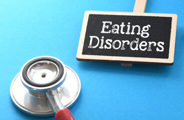Eating Disorders words on a small chalkboard next to a stethoscope.