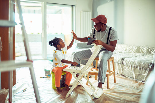 Father and daughter having fun while renovating at home