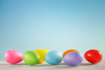 blue background with colored eggs in the foreground, there is room for text