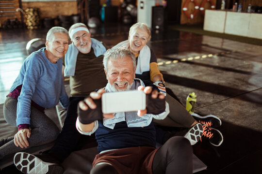 Diverse senior people taking a group photo in gym