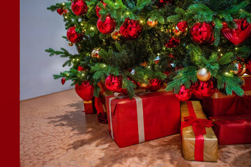 Fototapeta na wymiar Christmas gifts at the Christmas tree given by Santa Claus and Christmas lights and balls on tree