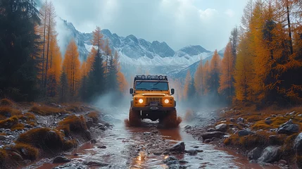 Fotobehang A 4x4 vehicle navigates a muddy trail amidst golden autumn trees, under the majestic snow-capped mountains, embodying the spirit of offroad adventure. © Valeriy